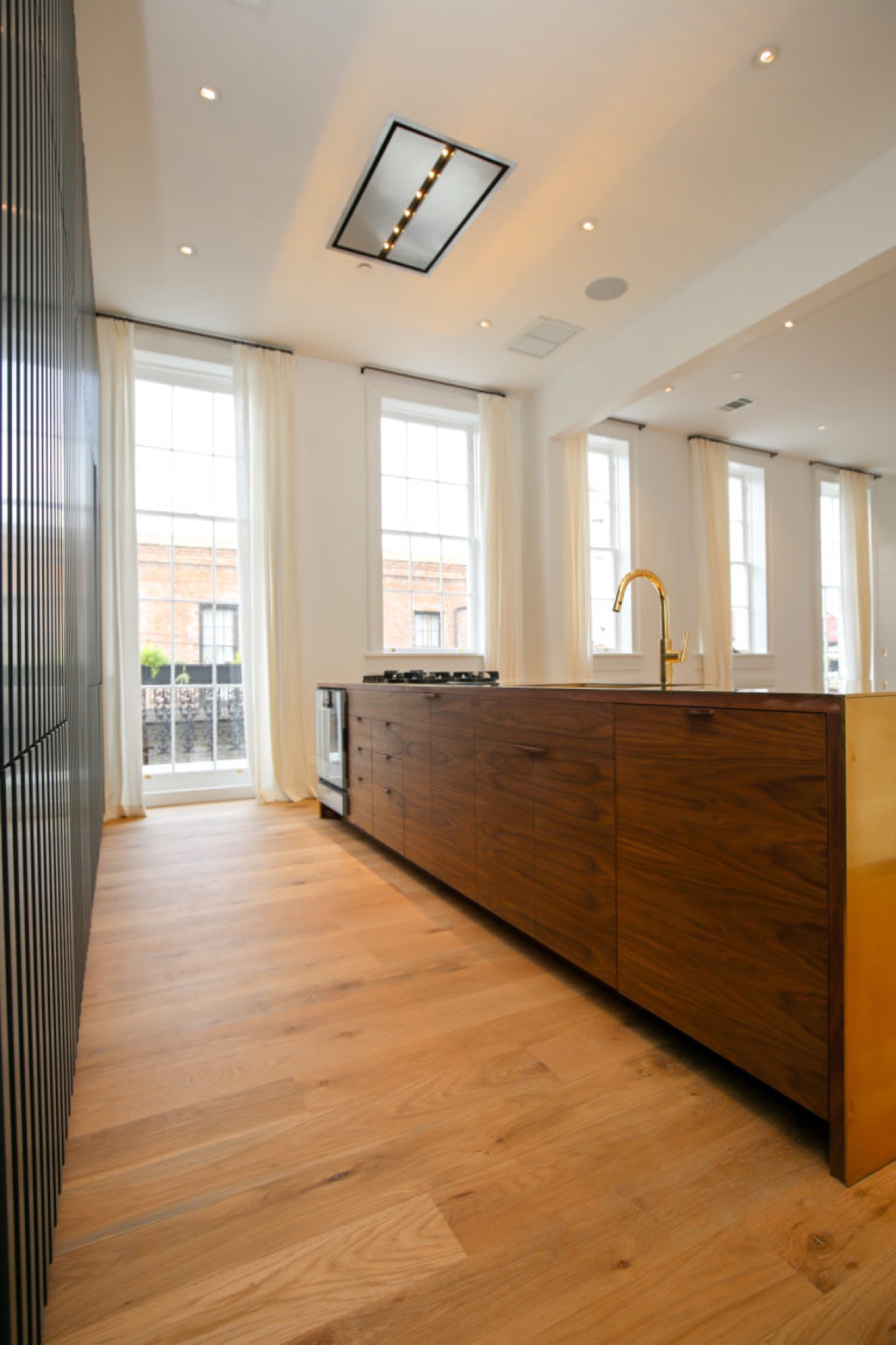 Walnut kitchen island cabinetry with a brass end panel