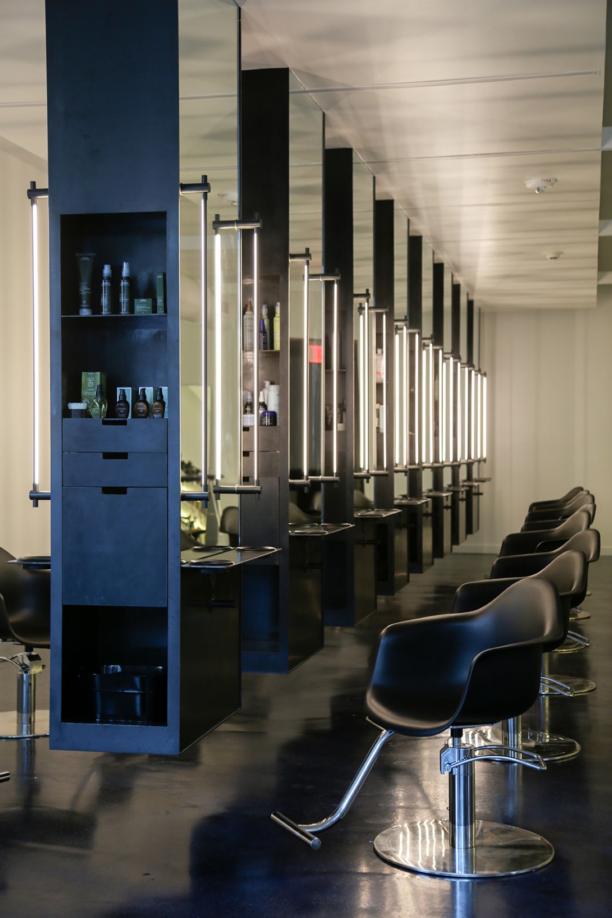 Salon stations with blackened steel towers and vertical light bars