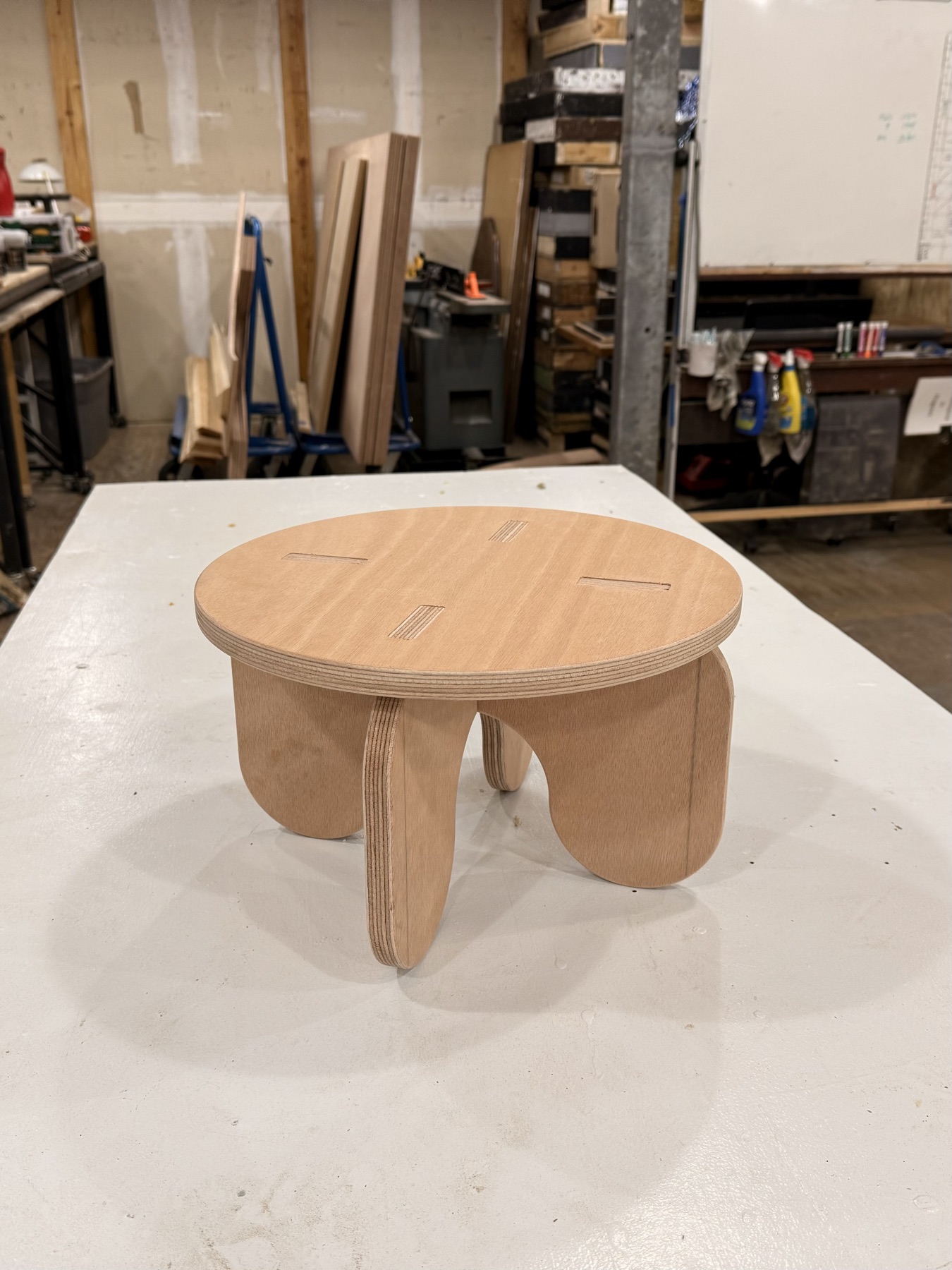 Round plywood stool with slotted legs