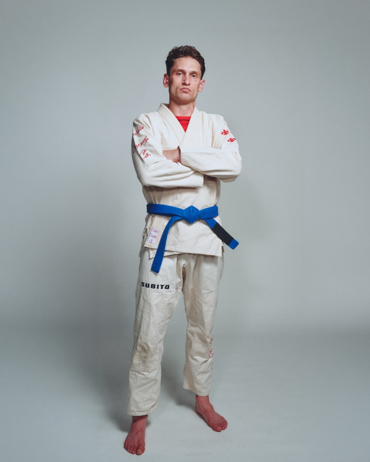 Athlete in a white Subito gi, studio shot