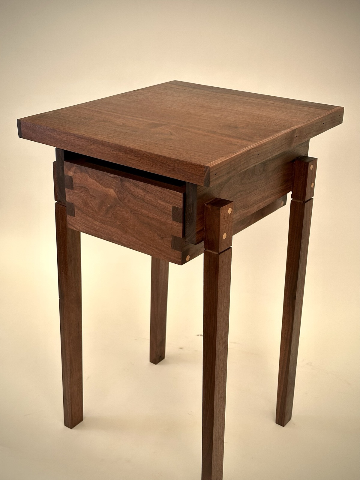 Walnut side table with a dovetailed drawer and pinned legs