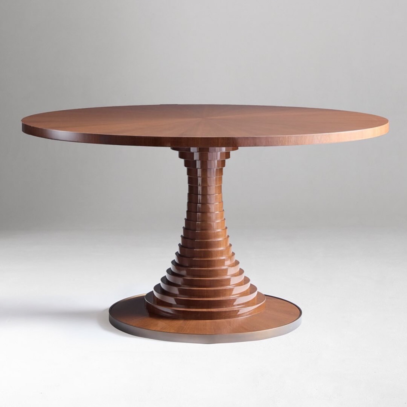 Round dining table on a stepped, lacquered pedestal