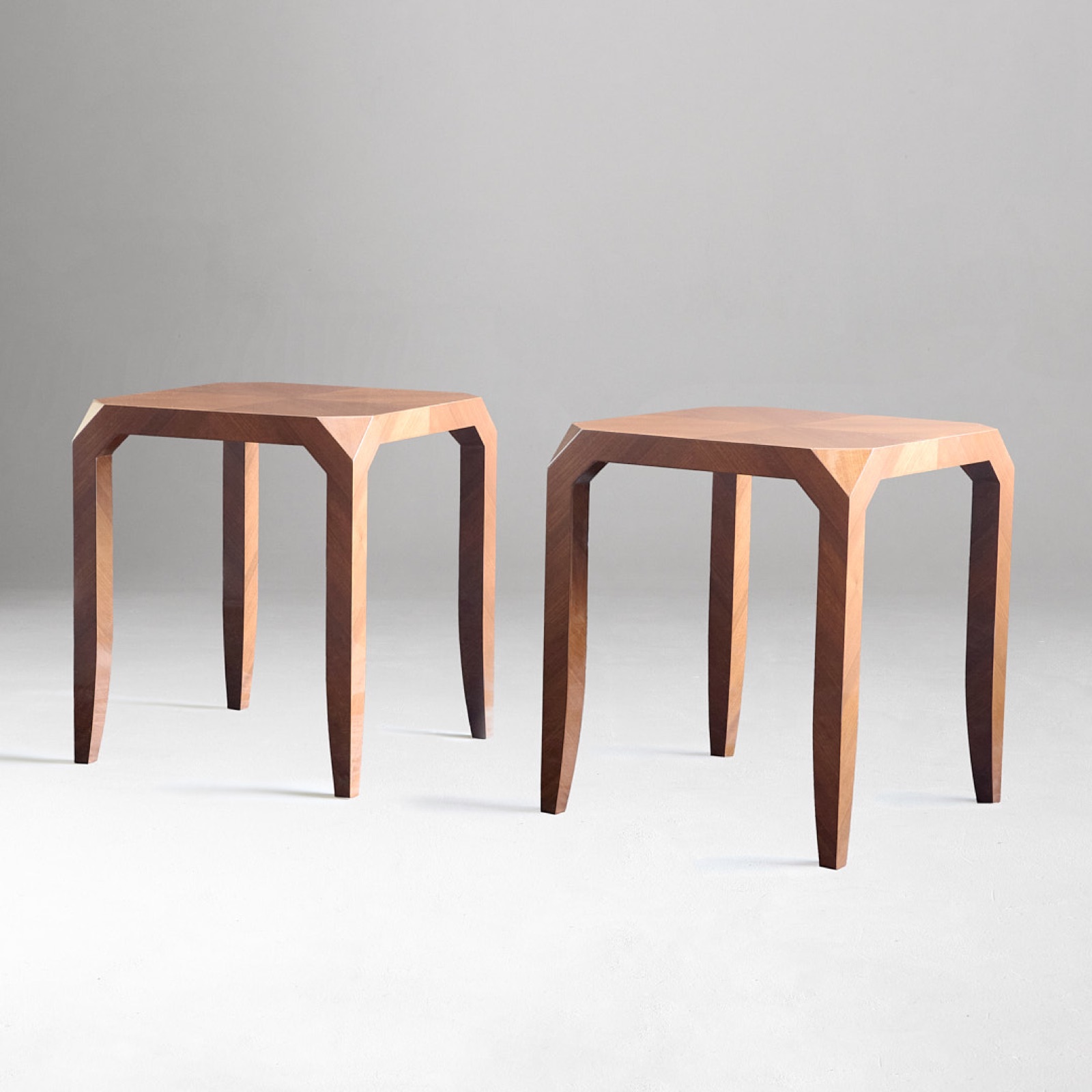 Pair of faceted side tables with quartered veneer tops